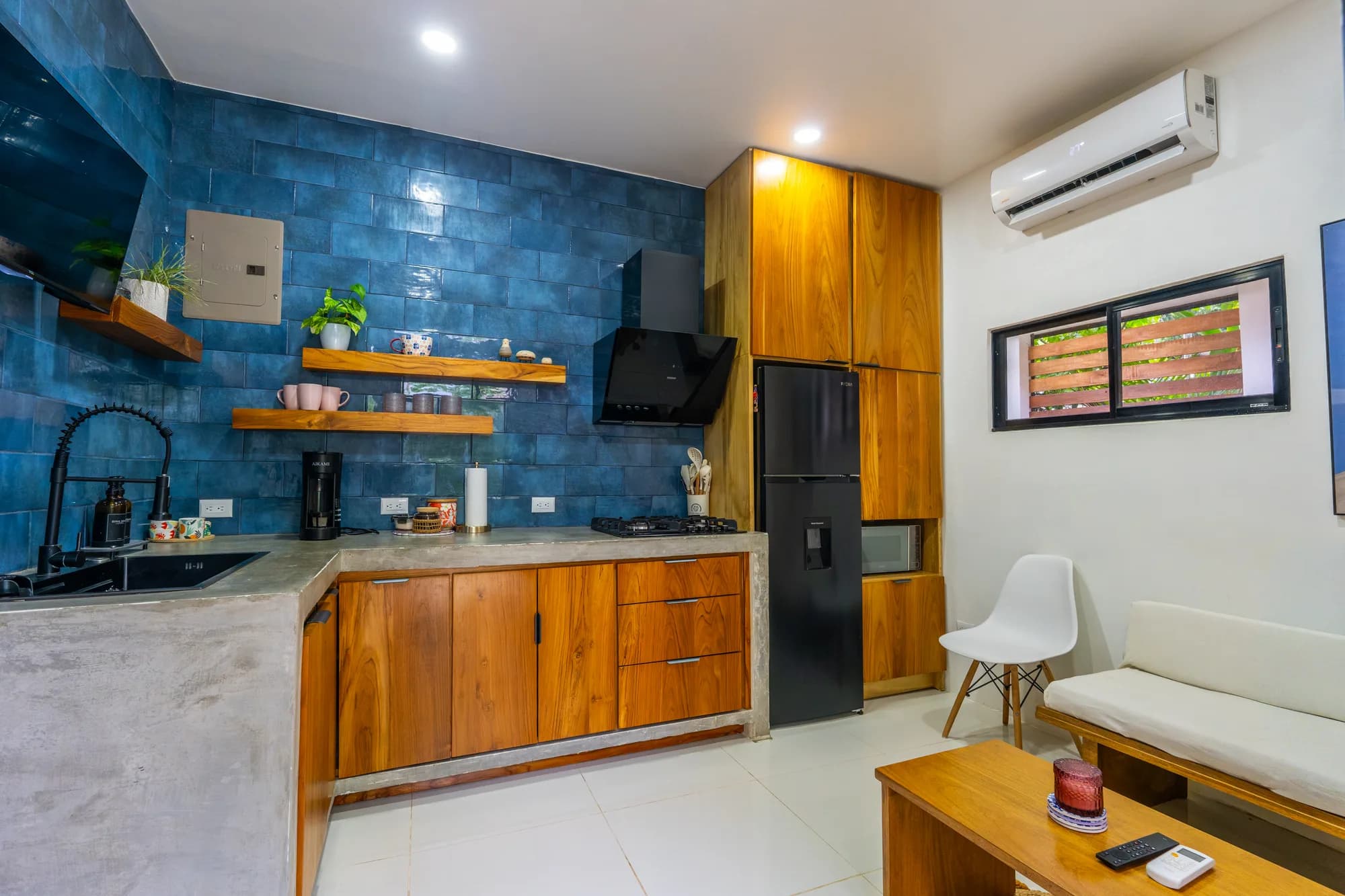 Morpho House kitchen and studio living area with blue tile backsplash and polished concrete counters