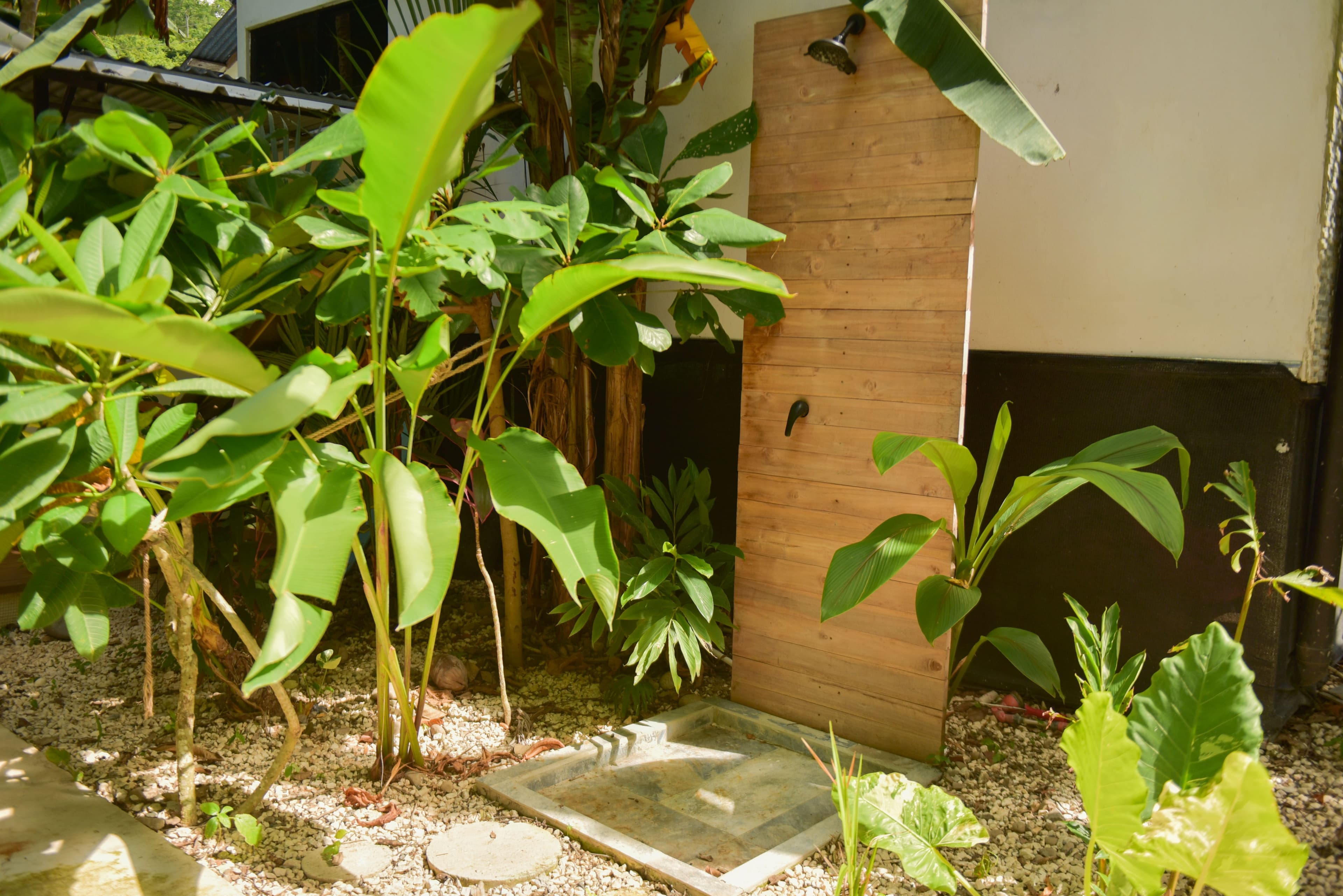Outdoor shower surrounded by tropical greenery