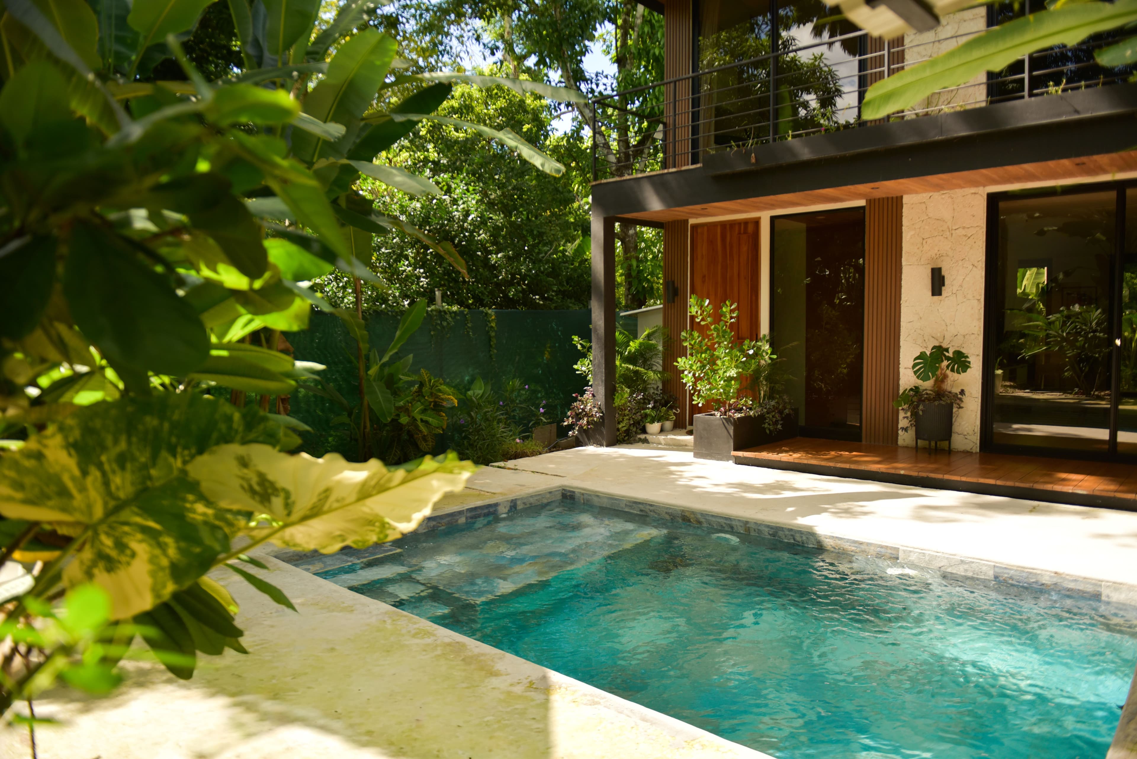 Shared pool area with lounge seating beside Riu House